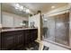 Bathroom featuring stylish vanity with granite countertop and a glass-enclosed shower with marble tile at 5448 Tulip Hill Ave, Las Vegas, NV 89141