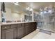 Bathroom with dual sink vanity, granite countertops, and large glass enclosed shower with neutral tile at 5448 Tulip Hill Ave, Las Vegas, NV 89141
