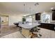 A kitchen with granite countertops, dark wood cabinets, and adjacent living spaces at 5448 Tulip Hill Ave, Las Vegas, NV 89141