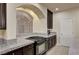 Well-lit kitchen with a black stovetop, granite countertops, and dark wood cabinets at 5448 Tulip Hill Ave, Las Vegas, NV 89141