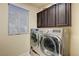 Bright laundry room with modern silver washer and dryer and storage at 5448 Tulip Hill Ave, Las Vegas, NV 89141