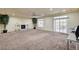 Spacious carpeted living room with a fireplace, ceiling fan and sliding glass door at 5448 Tulip Hill Ave, Las Vegas, NV 89141