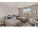 Inviting bedroom with twin beds, a plush chair, and natural light from the window at 5449 Hickory Tree St, Las Vegas, NV 89149