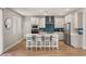 Modern kitchen with white cabinets, a blue backsplash, stainless steel appliances, and an island with seating at 5449 Hickory Tree St, Las Vegas, NV 89149