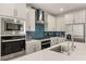 Modern kitchen featuring stainless steel appliances, white cabinets, and stylish backsplash at 5449 Hickory Tree St, Las Vegas, NV 89149