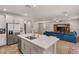 Spacious kitchen with a large island, stainless steel appliances, and an open view of the living room at 5449 Hickory Tree St, Las Vegas, NV 89149