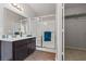 A well-lit bathroom offers a single sink vanity with a large mirror and a glass-enclosed shower at 556 Decidedly St, Henderson, NV 89015