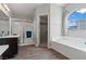 A bright bathroom features a glass-enclosed shower, soaking tub, and access to a walk-in closet at 556 Decidedly St, Henderson, NV 89015