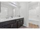 A well-maintained bathroom offers a large mirror, a double vanity, and a shower with white tile surround at 556 Decidedly St, Henderson, NV 89015