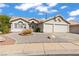 Charming home showcasing a well-maintained front yard with desert landscaping and a two-car garage at 556 Decidedly St, Henderson, NV 89015