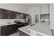 Modern kitchen featuring stainless steel appliances, quartz countertops, and dark wood cabinetry at 556 Decidedly St, Henderson, NV 89015