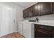 Laundry room with wood look floors, cabinets, and washer and dryer at 556 Decidedly St, Henderson, NV 89015