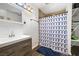 Bathroom with patterned shower curtain, wood-look floors, and vanity at 5912 Hollowridge Rd, North Las Vegas, NV 89031