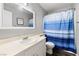 Bathroom featuring white vanity, blue striped shower curtain, and tile floors at 5912 Hollowridge Rd, North Las Vegas, NV 89031