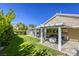 Beautiful backyard featuring a covered patio, green lawn, and mature trees at 6021 Winter Meadow St, Las Vegas, NV 89130