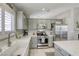 Updated kitchen with stainless steel appliances, farmhouse sink, and bright countertops at 6021 Winter Meadow St, Las Vegas, NV 89130