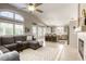 Open-concept living area showcasing a fireplace, a comfortable sectional, and seamless flow to the kitchen at 6021 Winter Meadow St, Las Vegas, NV 89130