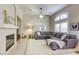 Comfortable living room featuring a fireplace, a plush grey sectional, and bright, natural light at 6021 Winter Meadow St, Las Vegas, NV 89130