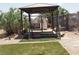 Outdoor backyard space featuring a pergola swing, artificial grass, and decorative features at 626 Kimberly Ave, Pahrump, NV 89060