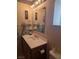 Traditional bathroom with wooden cabinets, sink, and a large mirror with decorative shelves at 626 Kimberly Ave, Pahrump, NV 89060