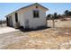 Exterior of a white outbuilding with a gated yard, an air conditioner, and dry landscaping at 626 Kimberly Ave, Pahrump, NV 89060