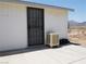 Exterior side view of a white shed with security door and evaporative cooler on a concrete slab at 626 Kimberly Ave, Pahrump, NV 89060