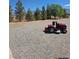 Gravel yard with a well-maintained riding lawn mower at 626 Kimberly Ave, Pahrump, NV 89060