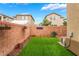 Enclosed backyard with low-maintenance green space, garden decor, and brick perimeter fencing at 6312 Snap Ridge St # 101, North Las Vegas, NV 89081