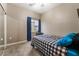 Neutral bedroom with a checkered bedspread, carpeted floors, and natural lighting at 6312 Snap Ridge St # 101, North Las Vegas, NV 89081