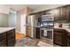 Well-lit kitchen with stainless steel appliances and dark wood cabinetry at 6312 Snap Ridge St # 101, North Las Vegas, NV 89081