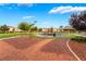 Community playground with picnic benches, walking paths, grassy areas, and mature trees at 6312 Snap Ridge St # 101, North Las Vegas, NV 89081