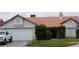 Single story home with a two car garage, red tile roof, and front yard with mature landscaping at 6432 Jean Lee Dr, Las Vegas, NV 89108