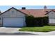 Single story home with a two car garage, red tile roof, and front yard with mature landscaping at 6432 Jean Lee Dr, Las Vegas, NV 89108