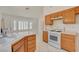 Bright kitchen featuring white appliances and tile flooring, with light wood cabinets at 6432 Jean Lee Dr, Las Vegas, NV 89108