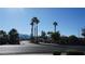 A wide street view of neighborhood with palm trees and mountains in the distance at 6432 Jean Lee Dr, Las Vegas, NV 89108