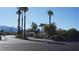 A wide street view of neighborhood with palm trees and mountains in the distance at 6432 Jean Lee Dr, Las Vegas, NV 89108