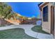 Backyard with turf and a paved patio with landscaping against a block wall at 644 Mauna Kea Pl, Henderson, NV 89011