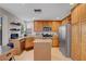 Charming kitchen boasts stainless steel appliances, wood cabinets, granite countertops, and tiled flooring at 644 Mauna Kea Pl, Henderson, NV 89011