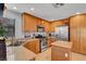 Well-lit kitchen with stainless steel appliances, wood cabinets, granite countertops, tile floor, and ample storage at 644 Mauna Kea Pl, Henderson, NV 89011