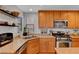 Well-maintained kitchen features stainless steel appliances, wood cabinets, granite countertops, and tile flooring at 644 Mauna Kea Pl, Henderson, NV 89011