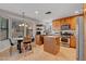 Well-lit kitchen features wooden cabinets, stainless steel appliances, tiled floors, and a cozy dining nook at 644 Mauna Kea Pl, Henderson, NV 89011