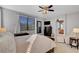Bright primary bedroom featuring a ceiling fan, a large window, and a sitting area, perfect for relaxation at 644 Mauna Kea Pl, Henderson, NV 89011