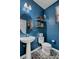 Stylish powder room with a pedestal sink, toilet, and decorative floating shelves at 644 Mauna Kea Pl, Henderson, NV 89011