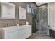 This modern bathroom is equipped with a double vanity, a sleek glass shower, and tile flooring at 6965 Tara Ave, Las Vegas, NV 89117