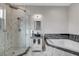 This bathroom has modern tile, a glass shower, and a luxurious soaking tub with dark marble accents at 6965 Tara Ave, Las Vegas, NV 89117