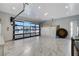 Spacious garage featuring a modern glass panel door, marble flooring, and ample storage cabinets at 6965 Tara Ave, Las Vegas, NV 89117