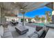 Inviting covered patio with a dining area, fireplace, seating, and a view of the refreshing pool and manicured backyard at 6965 Tara Ave, Las Vegas, NV 89117