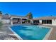 A sparkling backyard pool is the focal point, surrounded by lounge chairs and an outdoor kitchen under a pavilion at 6965 Tara Ave, Las Vegas, NV 89117