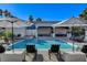 Backyard swimming pool with lounge chairs, umbrellas, a built-in kitchen, and comfortable seating areas at 6965 Tara Ave, Las Vegas, NV 89117