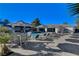 Outdoor pool area with ample seating, umbrellas, and a built-in kitchen, perfect for entertaining and relaxation at 6965 Tara Ave, Las Vegas, NV 89117